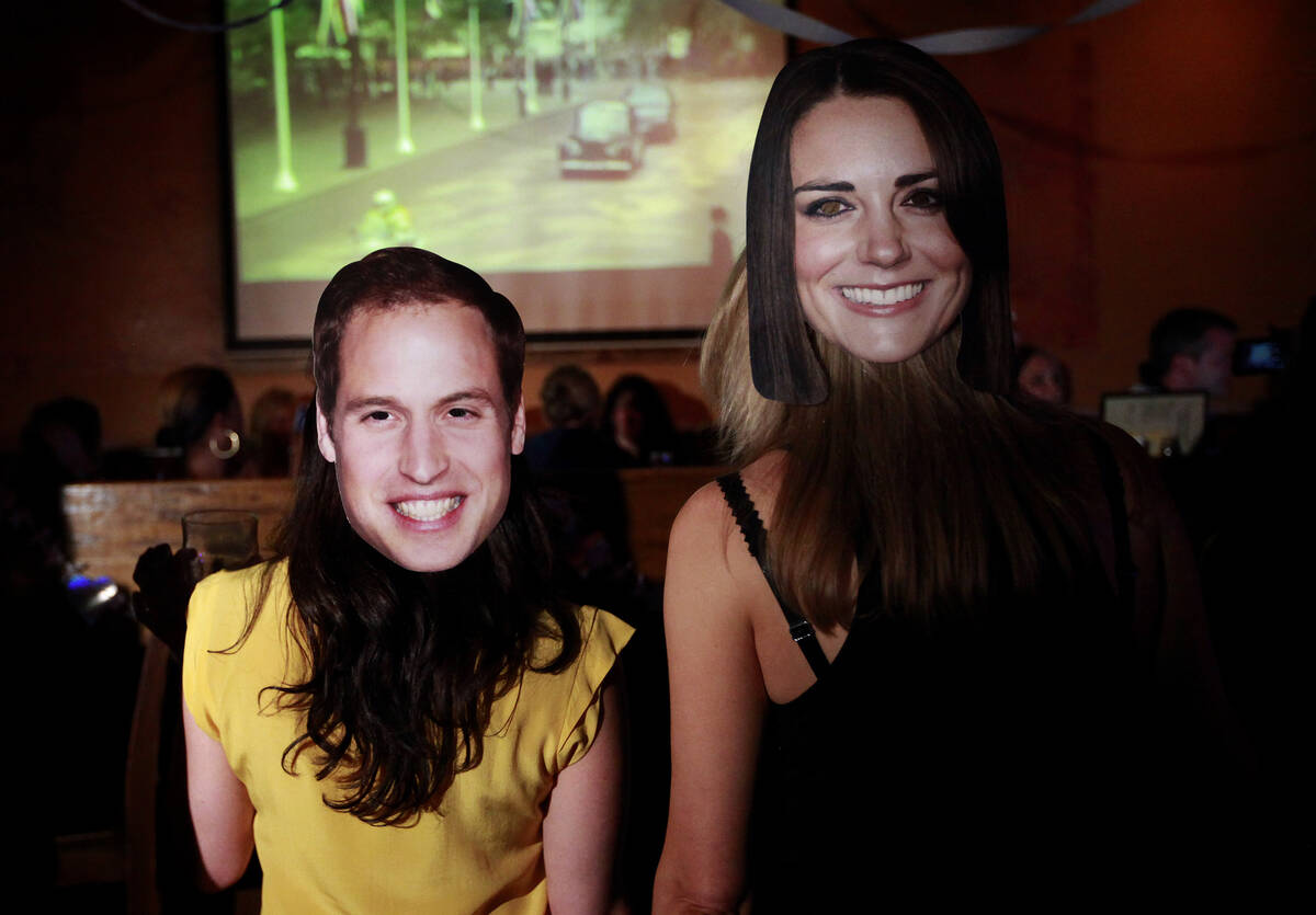 Pub patrons with Prince William and Kate Middleton masks watch the royal wedding of Prince Will ...