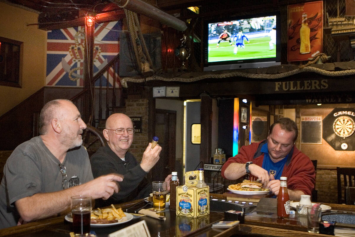 British native Paul Marks, left, watches soccer while having a bite to eat with his friend &quo ...