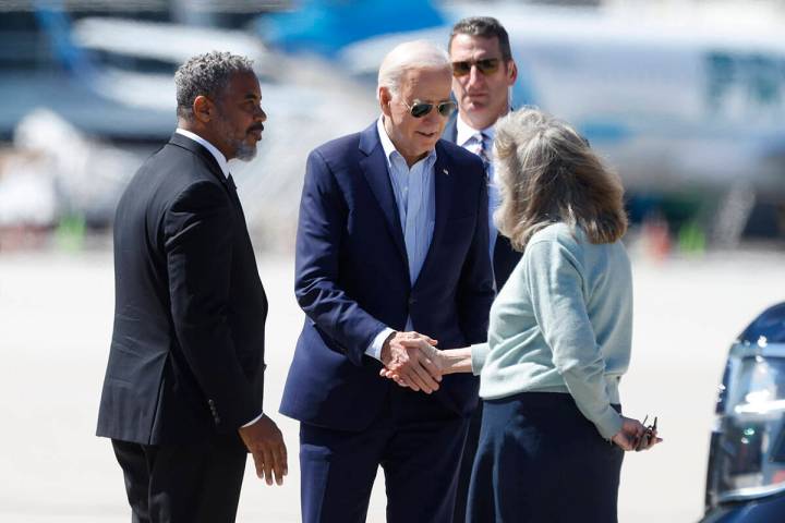 President Joe Biden is greeted by Rep. Steven Horsford, left, and Congresswoman Dina Titus afte ...