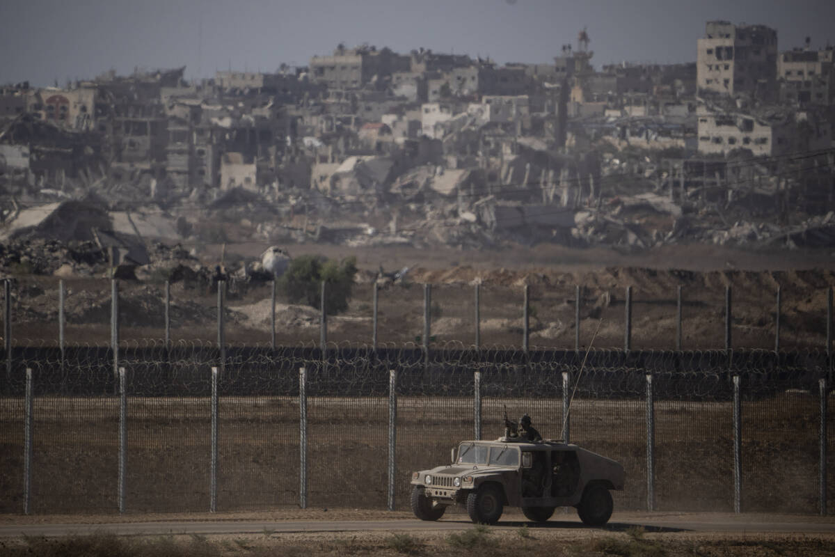 Israeli soldiers move near the Israeli-Gaza border, as seen from southern Israel, Monday, July ...