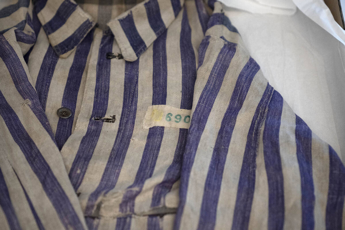 A striped uniform worn by a concentration camp prisoner is displayed in a textiles conservation ...