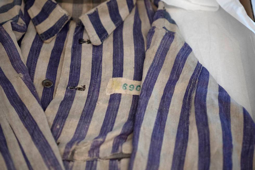 A striped uniform worn by a concentration camp prisoner is displayed in a textiles conservation ...