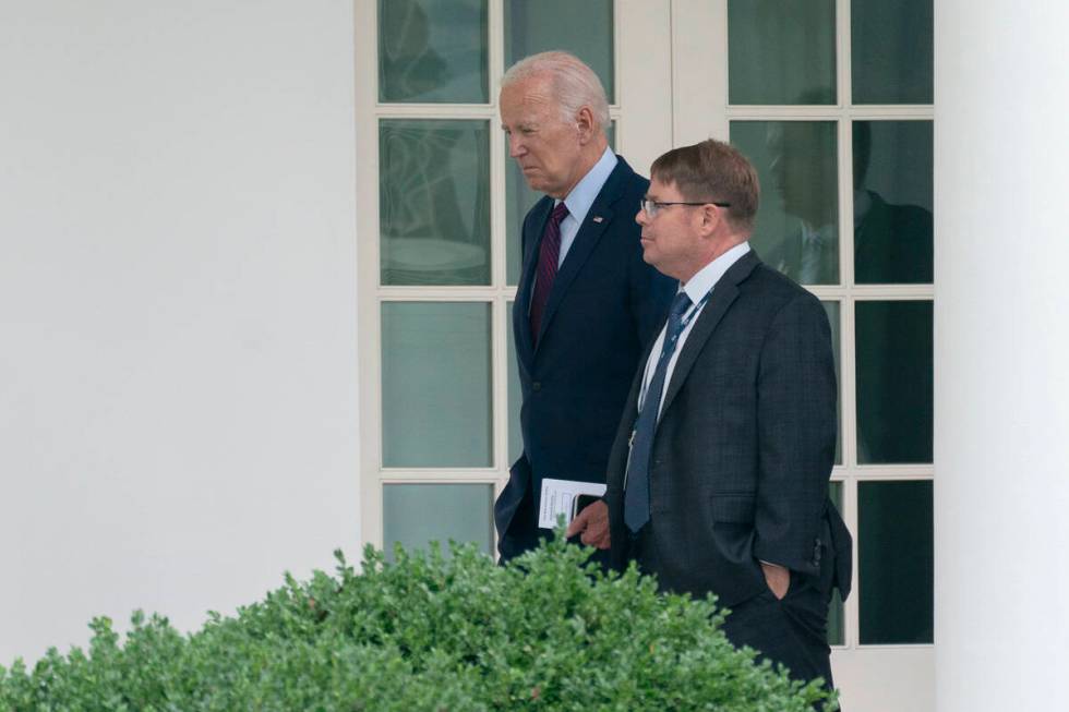 FILE - President Joe Biden walks along the Colonnade at the White House with his physician Kevi ...