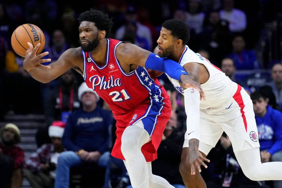 FILE - Philadelphia 76ers' Joel Embiid, left, tries to hang onto the ball against Los Angeles C ...