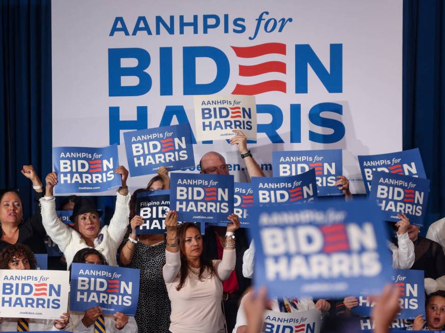 Supporters wave signs at a campaign event for Vice President Kamala Harris at Resorts World Las ...