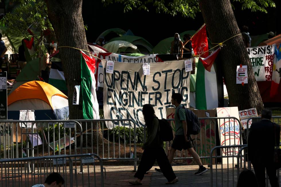 FILE - People walk past the Gaza Solidarity Encampment at the University of Pennsylvania in Phi ...