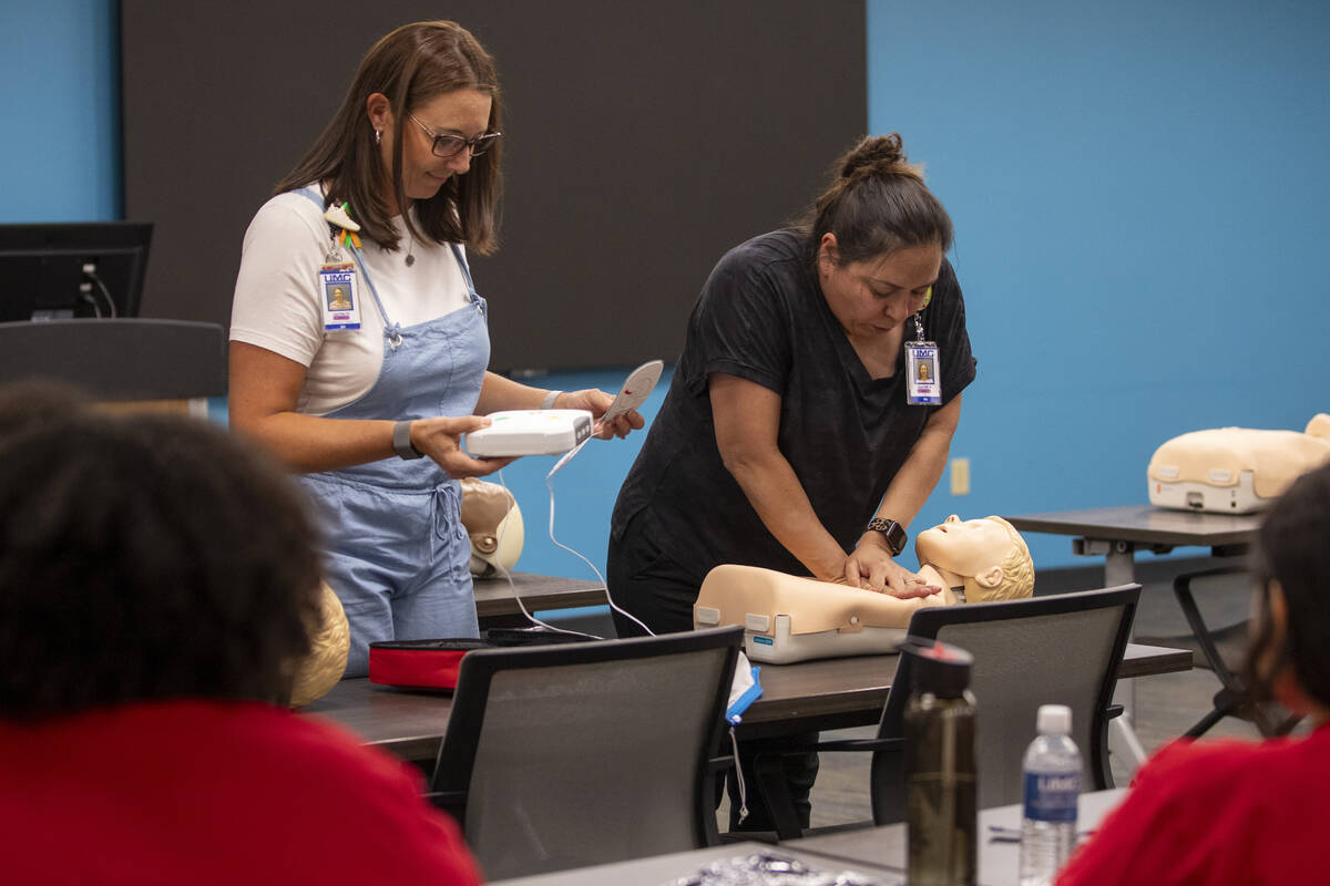 R.N. Jamie Hurley, left, and R.N. Xochitl Kambak, right, teach campers how to perform CPR with ...