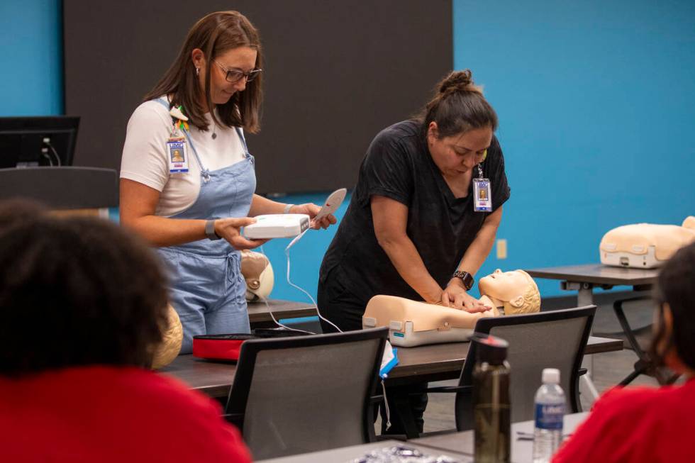 R.N. Jamie Hurley, left, and R.N. Xochitl Kambak, right, teach campers how to perform CPR with ...