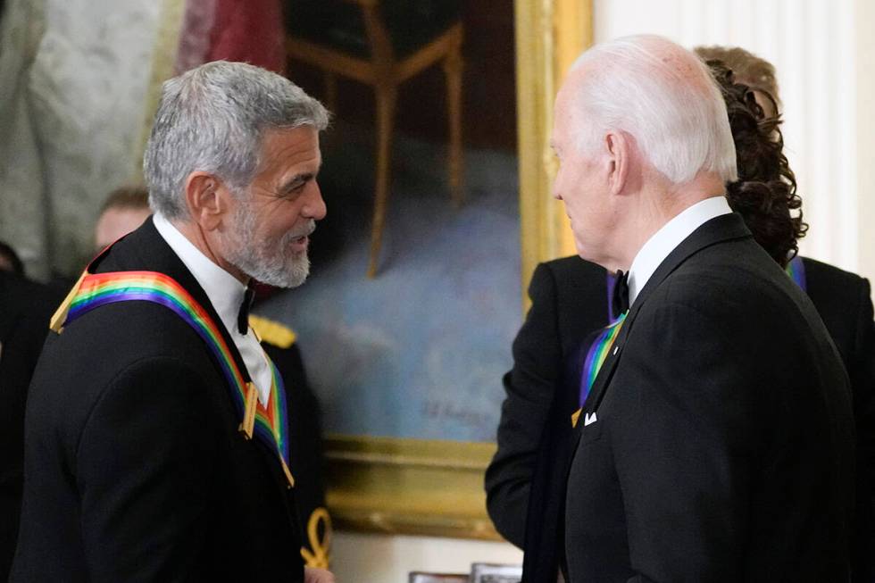 FILE - President Joe Biden shakes hands with actor, director and producer George Clooney during ...