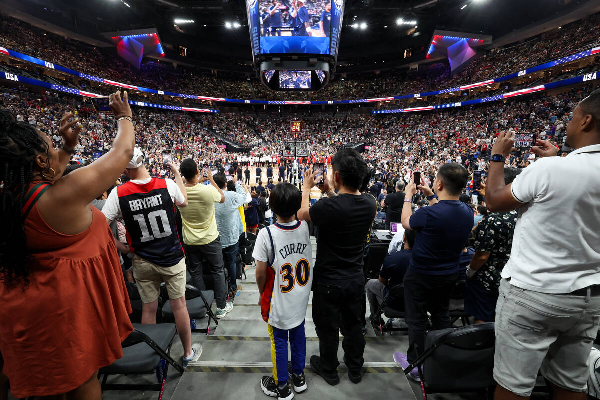 Fans stand as starting lineups are announced before a showcase basketball game between the USA ...
