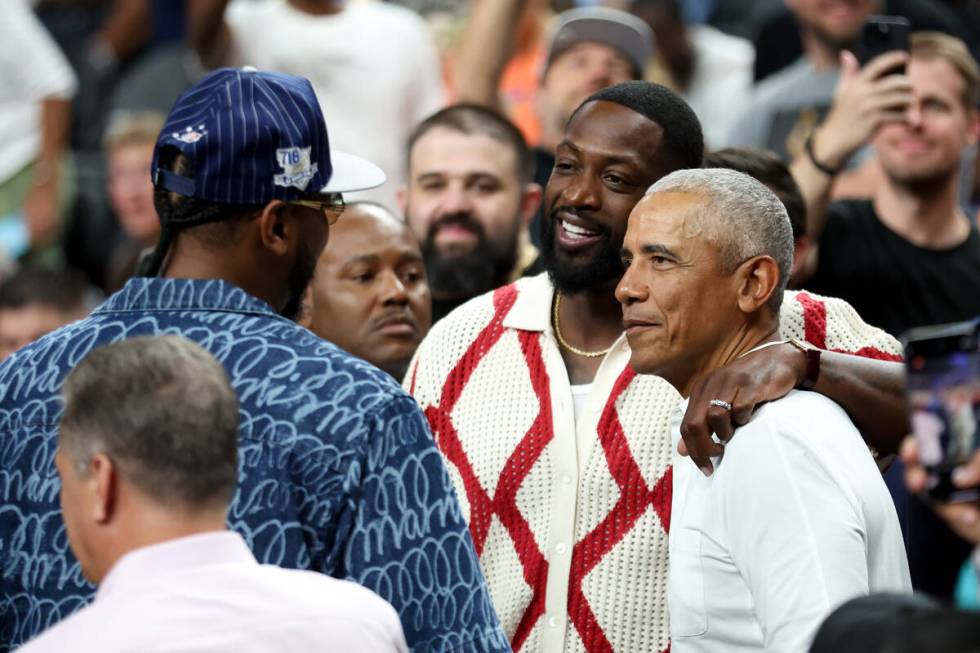 President Barack Obama chats with Carmelo Anthony, left, and Dwayne Wade during the first half ...