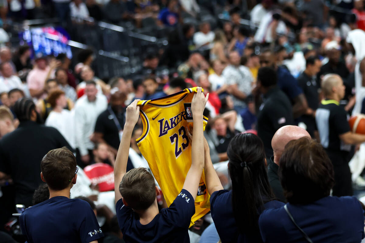 Fans hold up merchandise to USA forward LeBron James (6) on the bench during the second half of ...