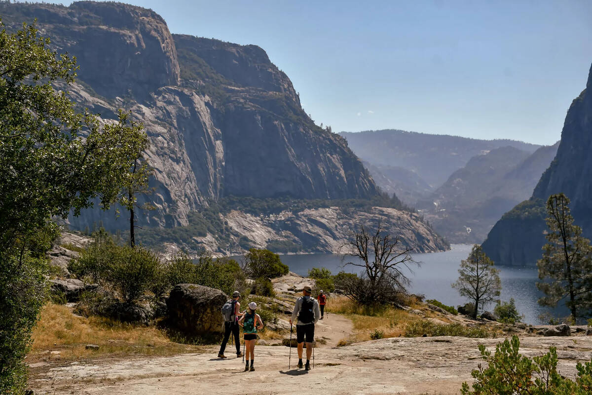 Hikers navigate a trail near the Hetchy Hetchy Reservoir in July 2023. The National Park Servic ...