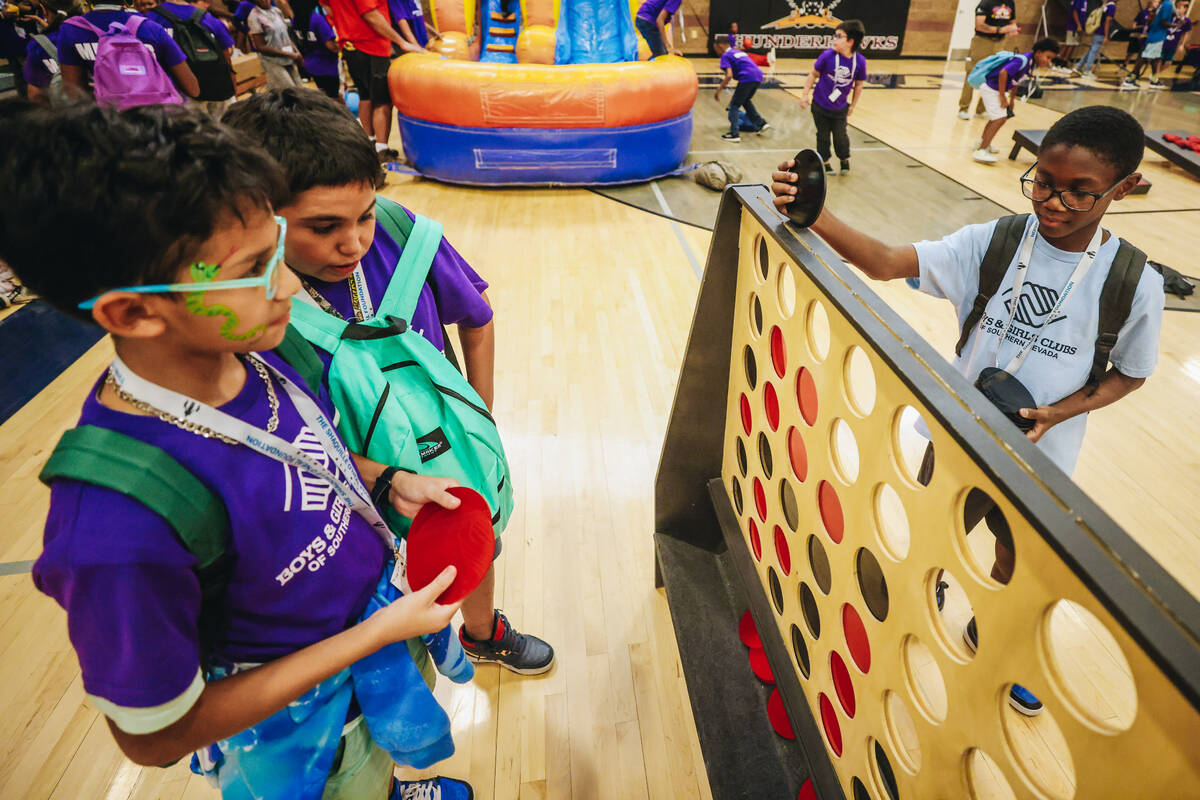 Boys & Girls club members play a game of Connect 4 during the Shaq-to-School event at Mario ...