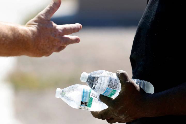 Darryl Walker, right, a homeless, talks to a Help of Southern Nevada outreach worker near Mount ...