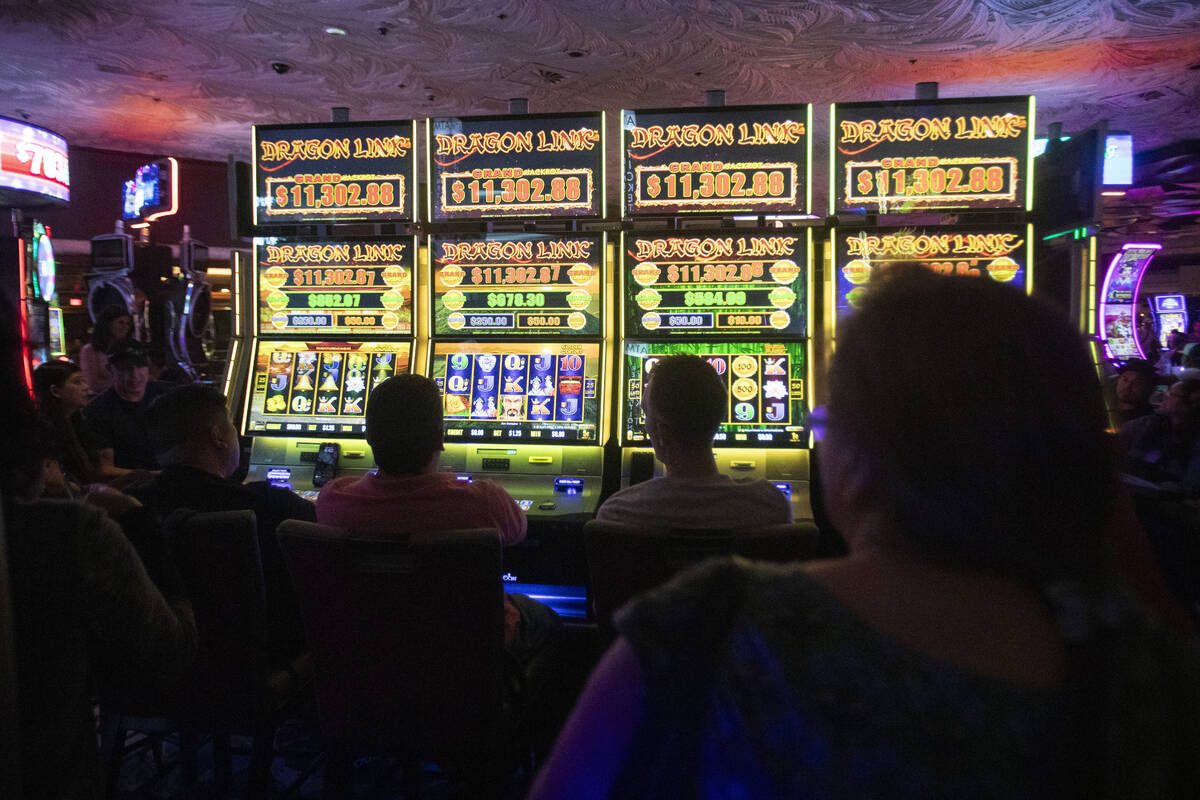 Tourists fill the seats of usable slot machines as more are turned off at The Mirage, Wednesday ...