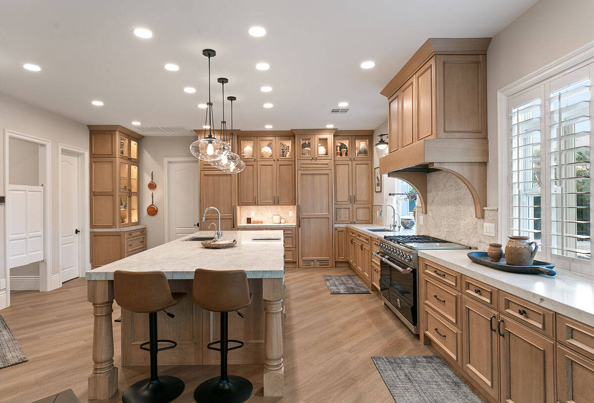 The fully remodeled kitchen showcases custom quarter-sawn oak cabinets with Taj Mahal leathered ...