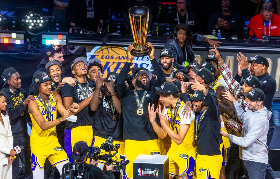 Los Angeles Lakers forward LeBron James (23) holds up the winning trophy about teammates after ...