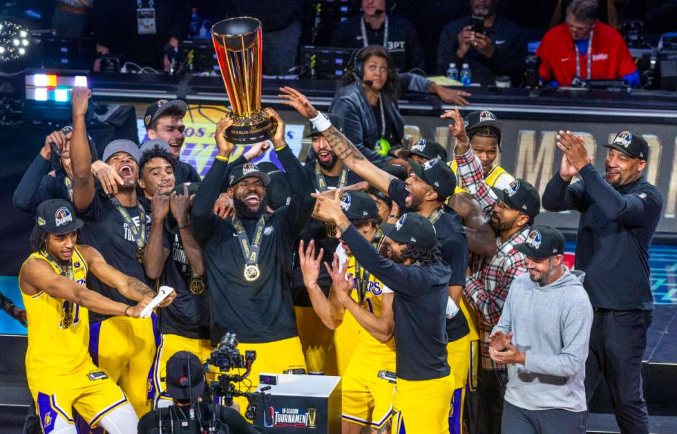 Los Angeles Lakers forward LeBron James (23) holds up the winning trophy about teammates after ...