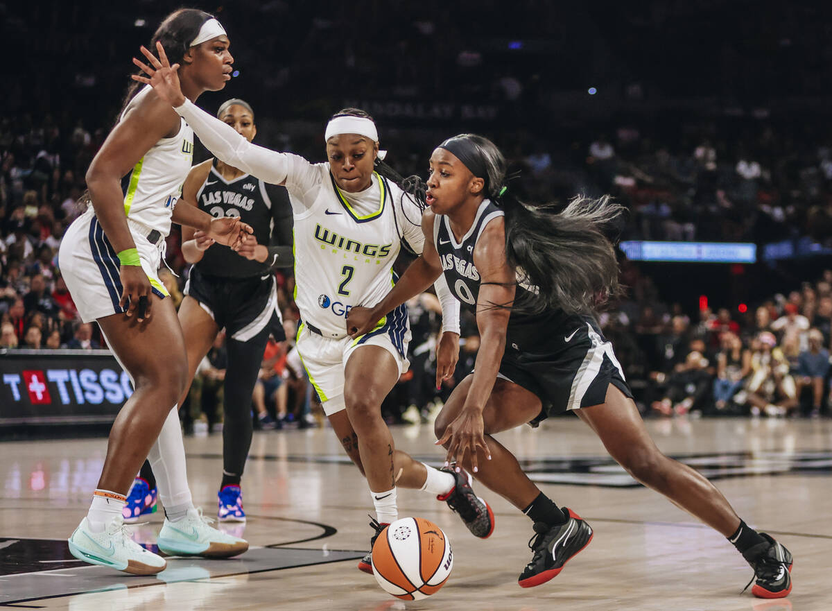 Aces guard Jackie Young (0) drives the ball to the hoop as Dallas Wings guard Odyssey Sims (2) ...