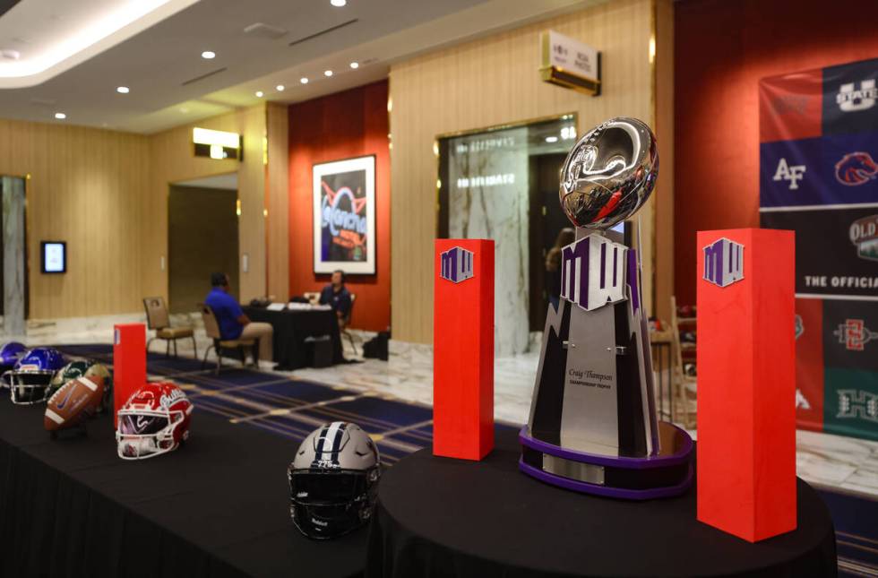 A Mountain West Championship trophy on display alongside team helmets at the Mountain West Foot ...