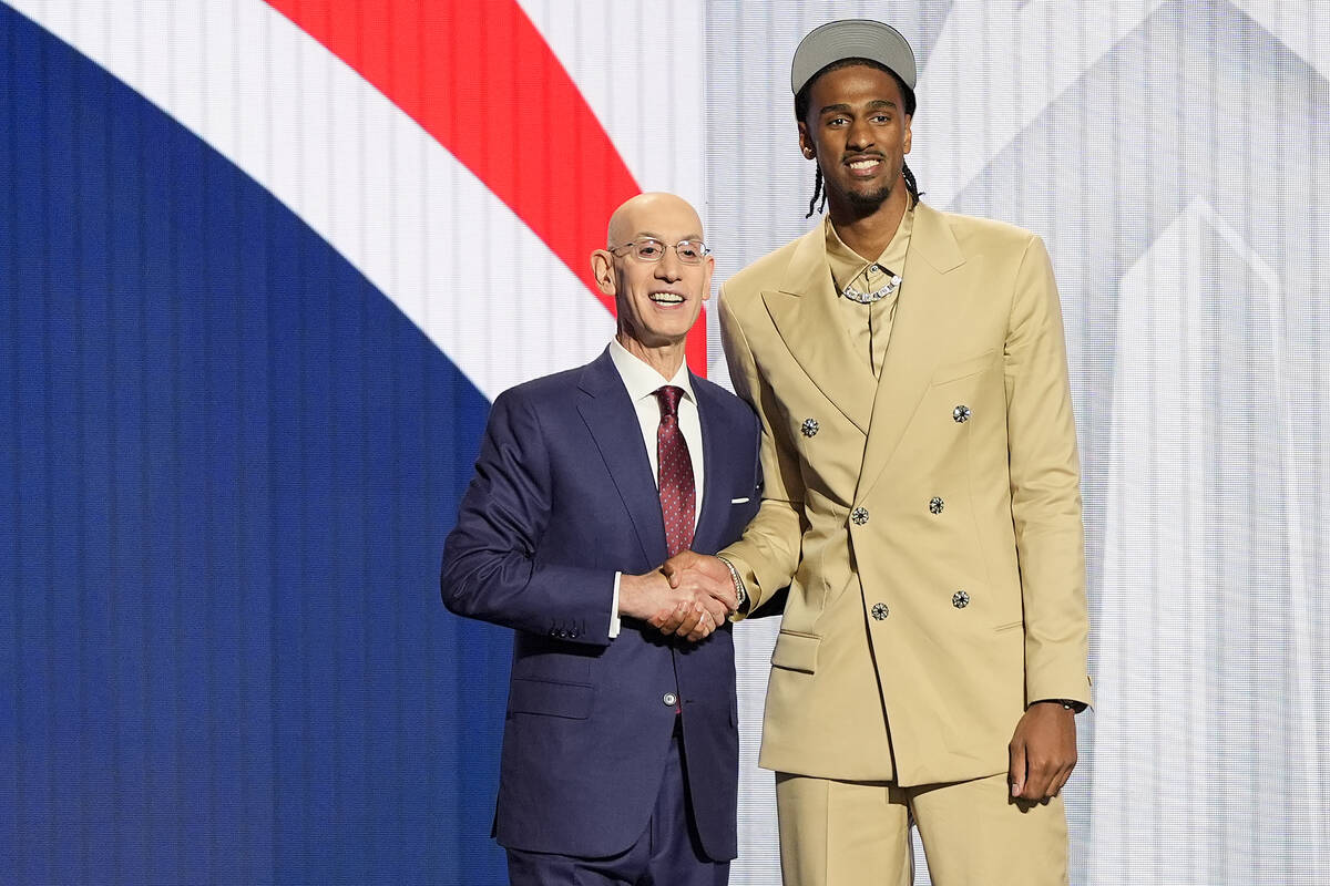 Alex Sarr, right, poses for a photo with NBA commissioner Adam Silver after being selected as t ...