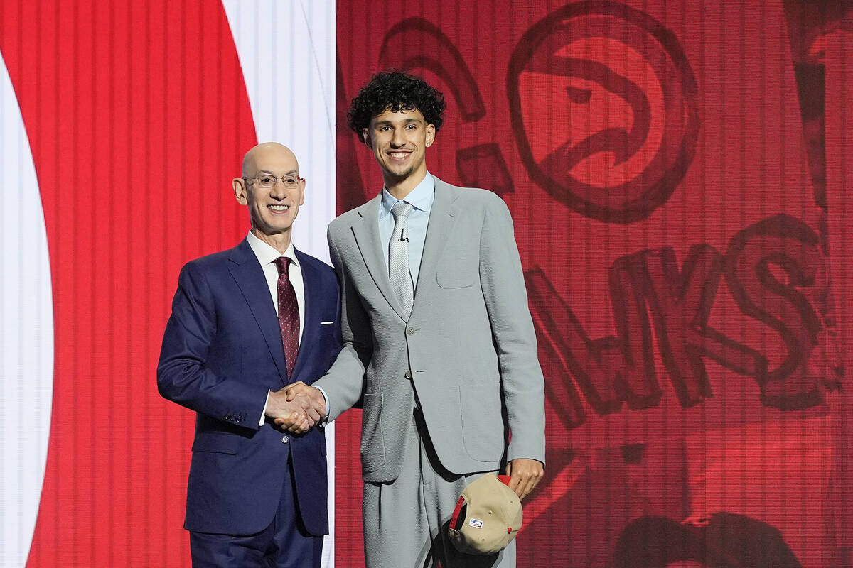 Zaccharie Risacher, right, poses for a photo with NBA commissioner Adam Silver after being sele ...