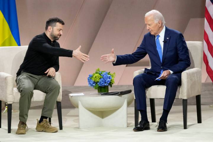 President Joe Biden, right, reaches to shake the hand of Ukraine's President Volodymyr Zelensky ...