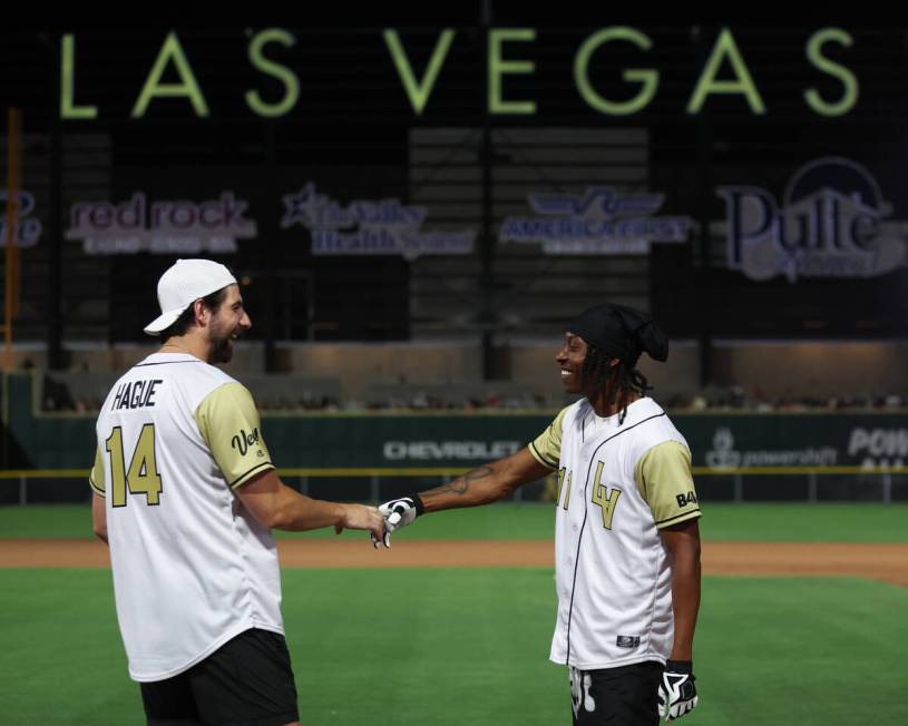 Golden Knights defenseman Nic Hague, left, congratulates his teammate Ricky White, a football p ...