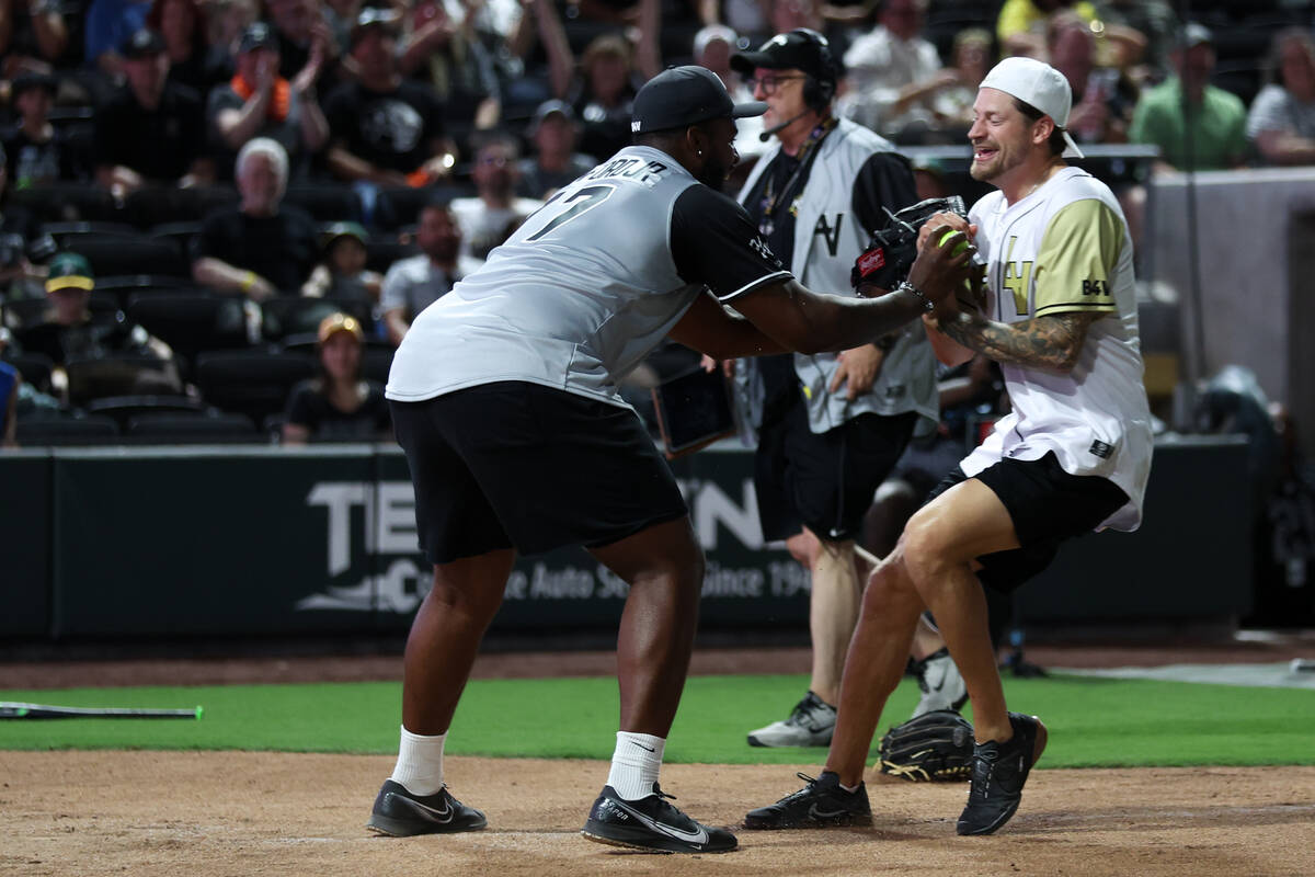 The Raiders’ Thayer Munford Jr., left, tags out Golden Knights goaltender Adin Hill duri ...