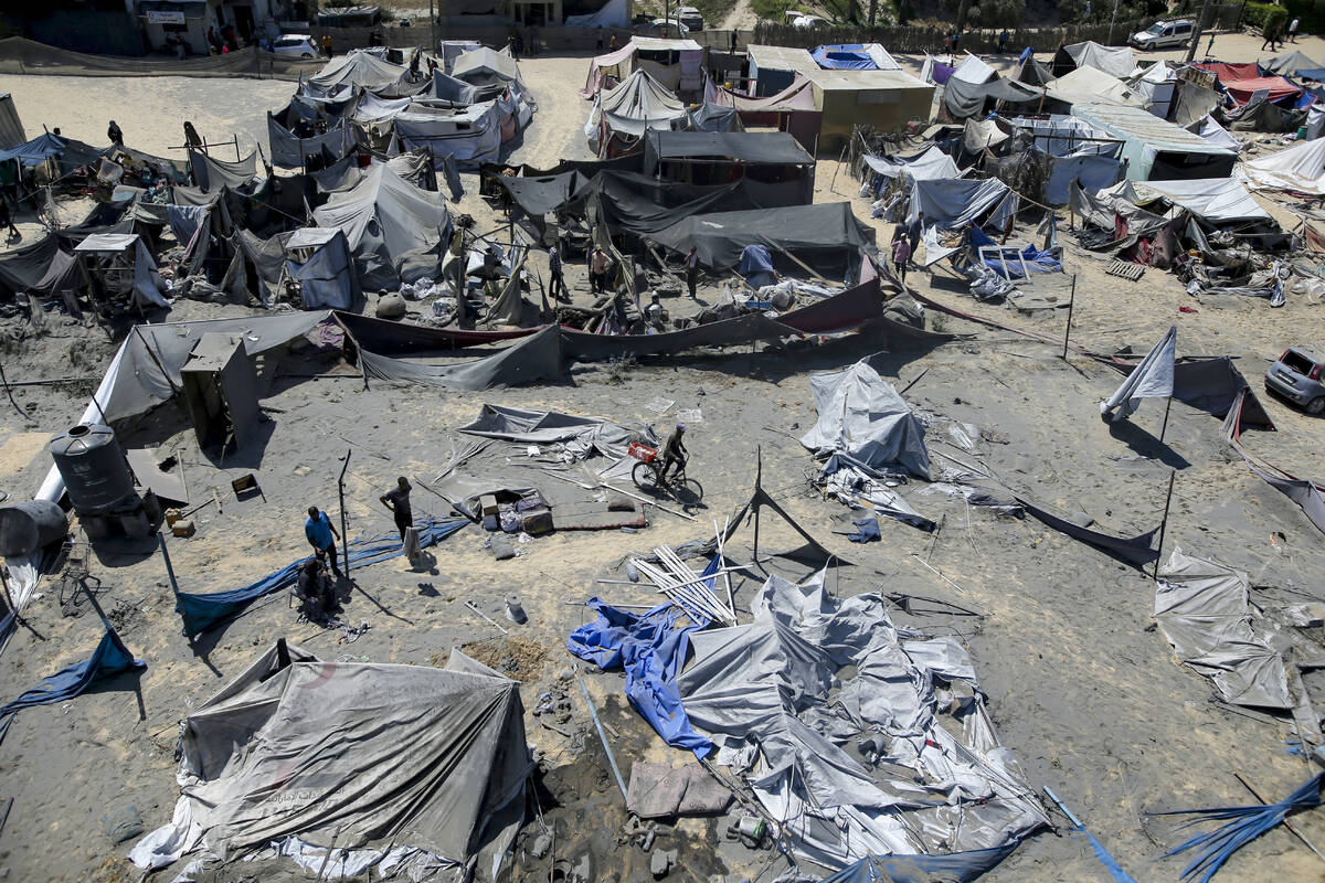 Palestinians inspect the damage at a site hit by an Israeli bombardment on Khan Younis, souther ...