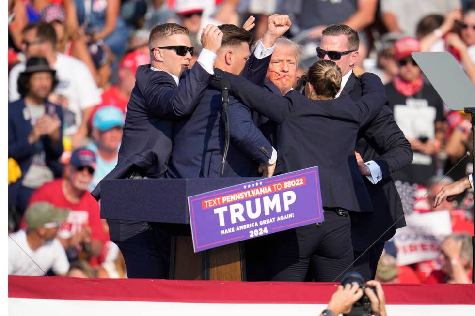 Republican presidential candidate former President Donald Trump is helped off the stage at a ca ...