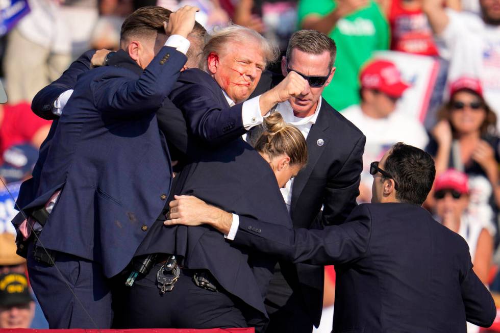 Republican presidential candidate former President Donald Trump is helped off the stage by U.S. ...