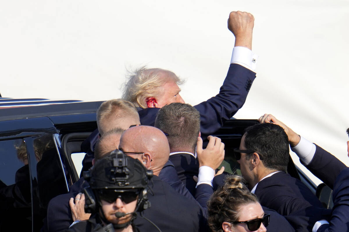 Republican presidential candidate former President Donald Trump pumps his fist as he is escorte ...