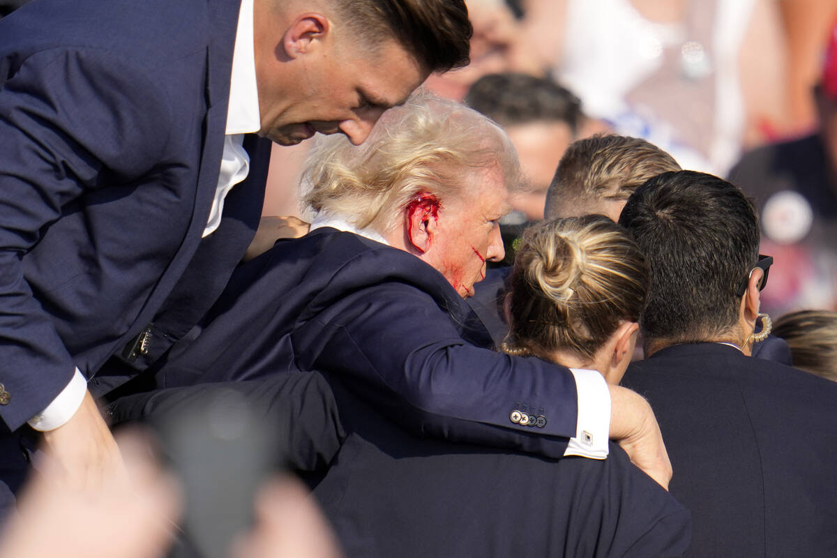 Republican presidential candidate former President Donald Trump is helped off the stage at a ca ...