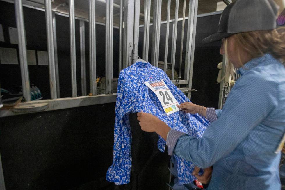 Amber Hofmarer, of Wisconsin, pics the hip number of Isaac Kent to a shirt before the Mustang C ...