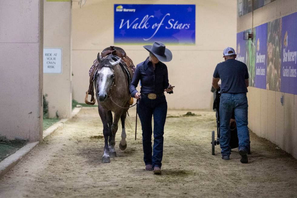 Competitors walk their mustangs to the animal pens during the Mustang Challenge at South Point ...