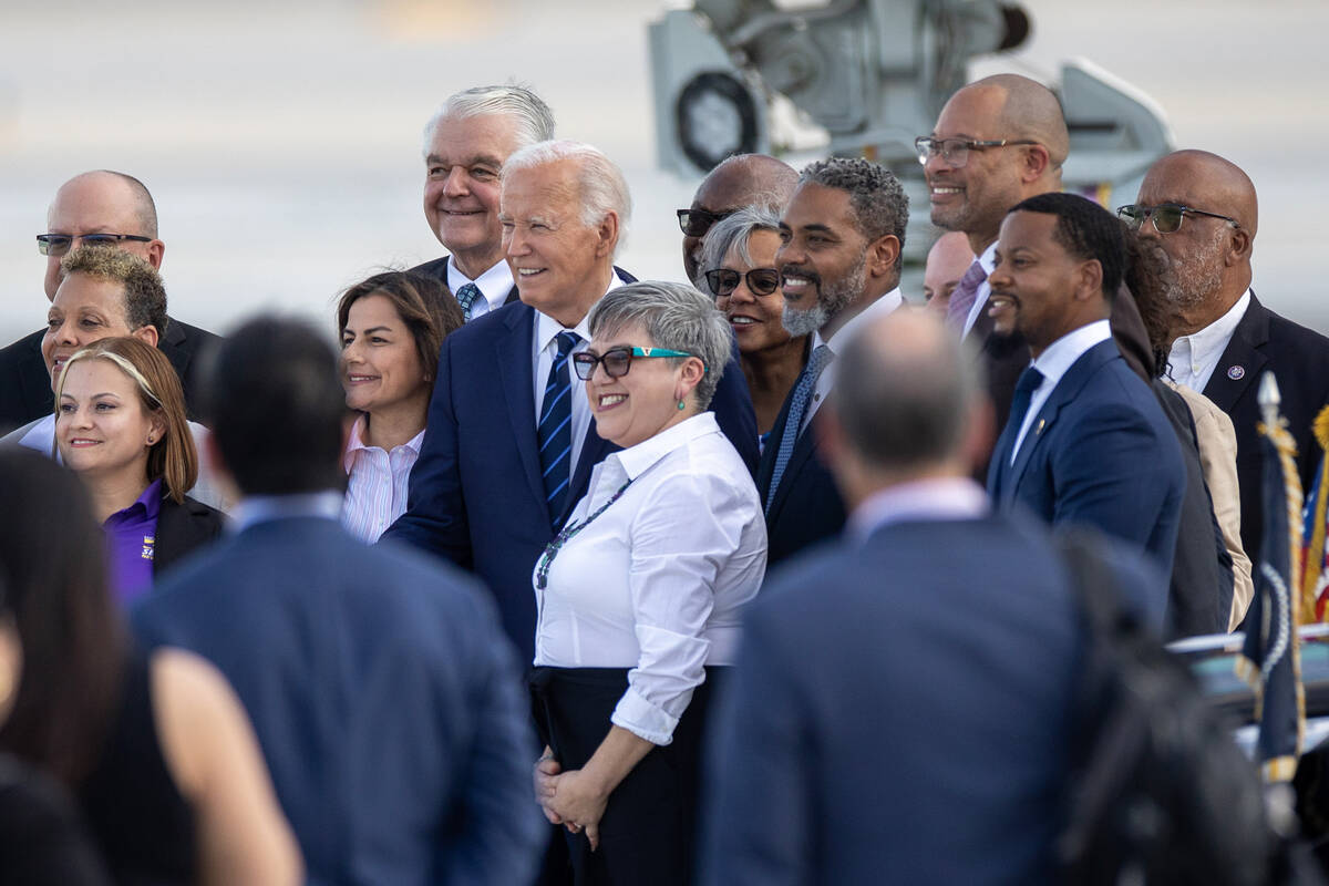 President Joe Biden takes a group photograph after exiting Air Force One at Harry Reid Internat ...