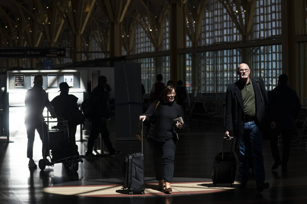 Passengers walk through the terminal at Ronald Reagan Washington National Airport, Tuesday, Apr ...