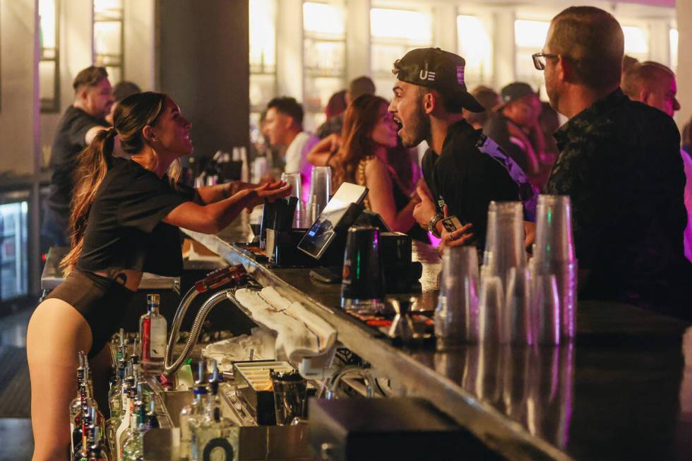 A bartender serves a customer during a soft opening event at Substance, a new nightclub at Neon ...