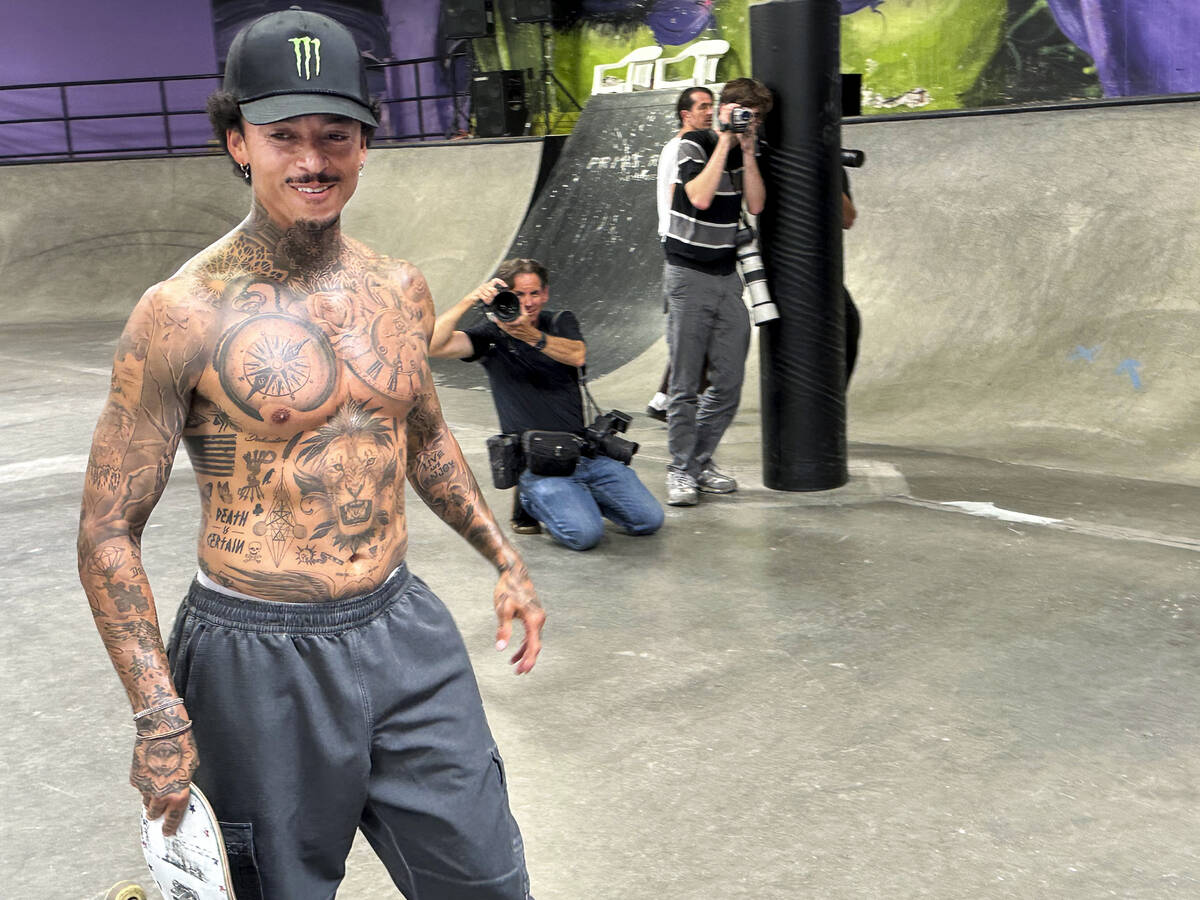 Nyjah Huston smiles as he walks past photographers at his private skate park in San Clemente, C ...