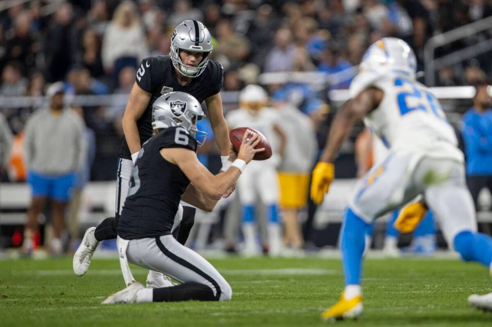 Raiders place kicker Daniel Carlson (2) prepares to kick as Raiders punter AJ Cole (6) goes to ...