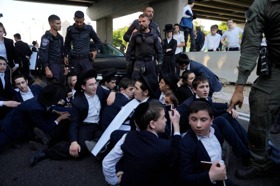 Israeli Police are deployed as ultra-Orthodox Jewish youth block a road to protest military rec ...
