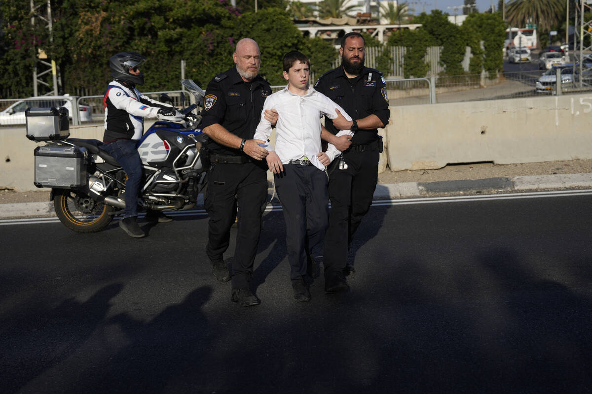 Israeli Police remove an ultra-Orthodox Jewish youth blocking a road to protest military recrui ...