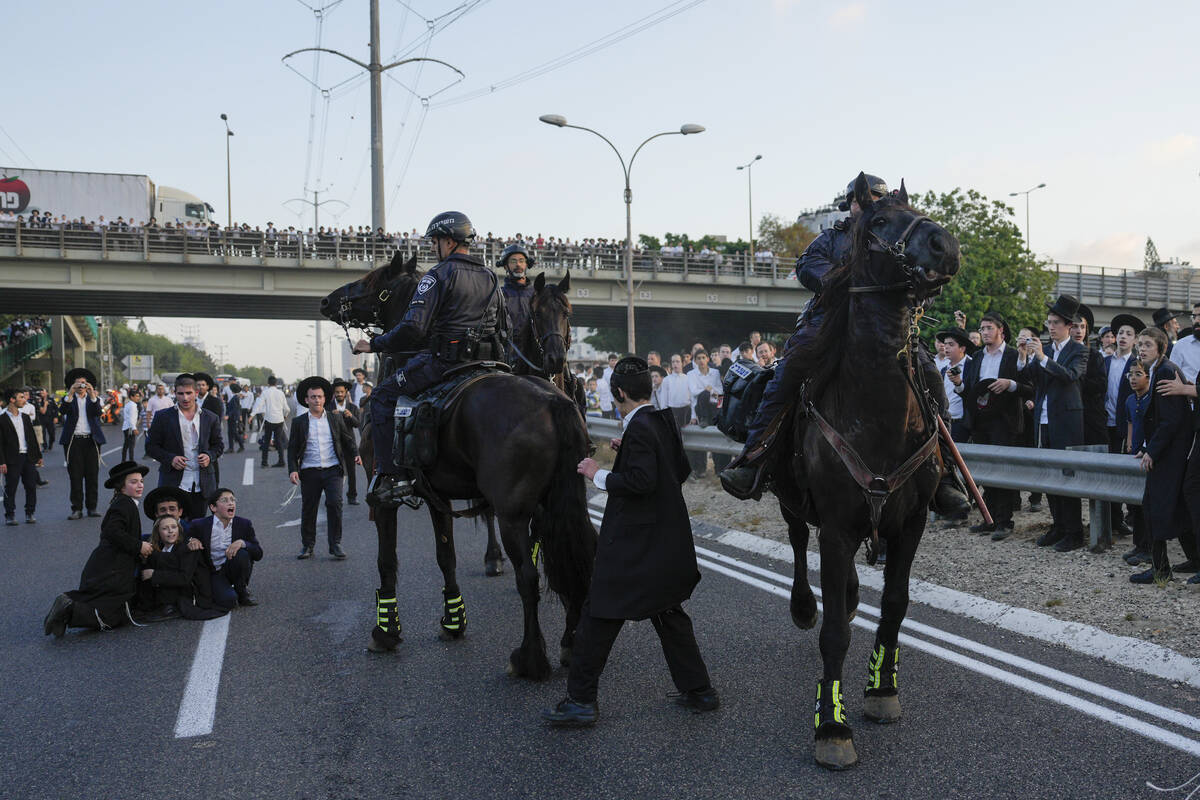 Israeli mounted police disperse Ultra-Orthodox Jews blocking a highway during a protest against ...