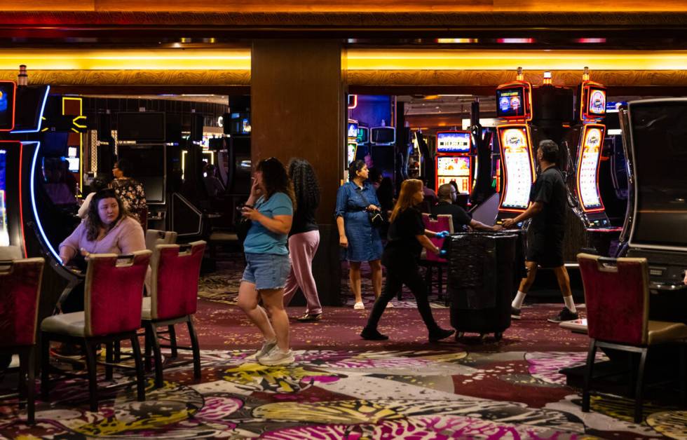People walk the casino floor as others play slots during the final night of operations and gami ...