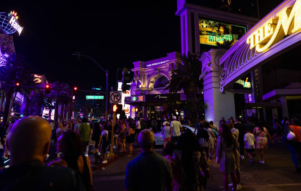 People walk the Las Vegas Strip after the final scheduled volcano show during the final night o ...