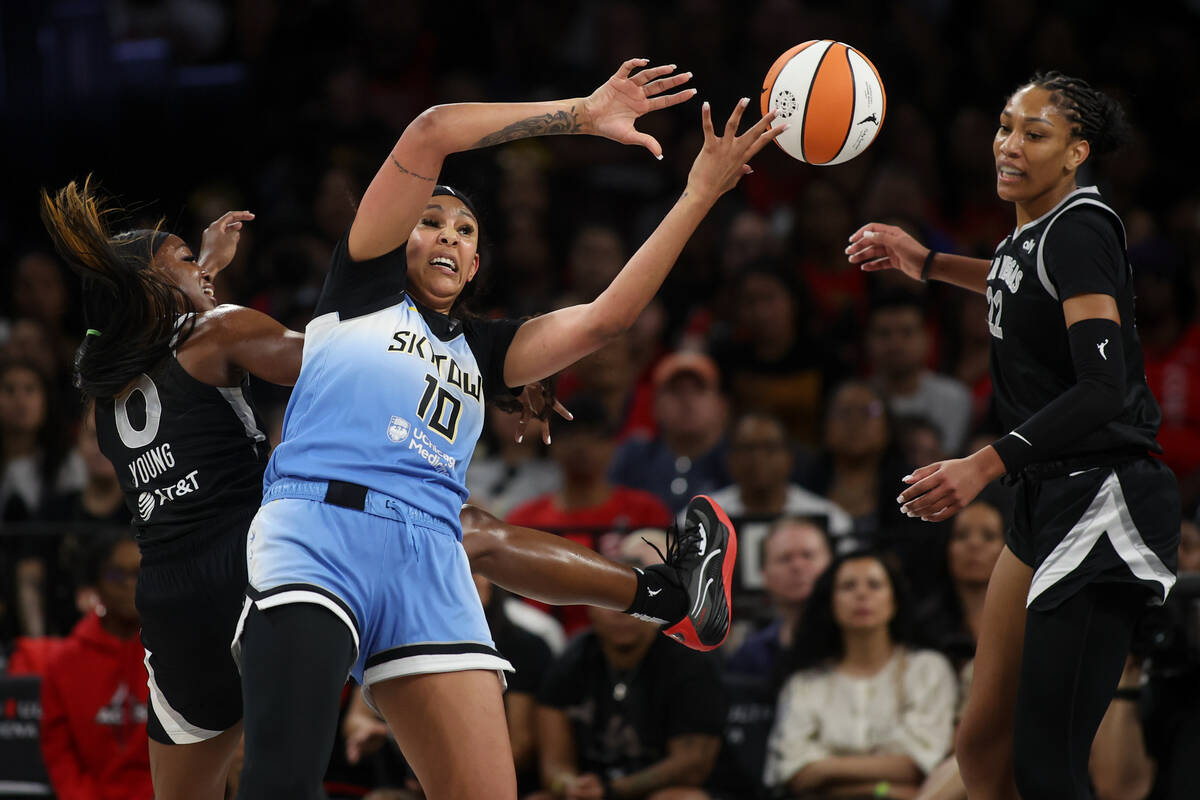 Las Vegas Aces guard Jackie Young (0) and Chicago Sky center Kamilla Cardoso (10) struggle for ...