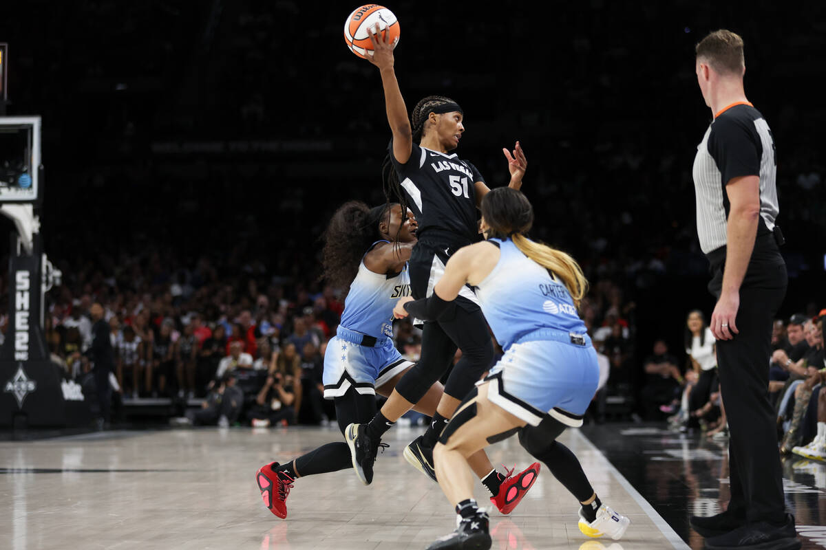 Las Vegas Aces guard Sydney Colson (51) passes the ball behind her while Chicago Sky guards Dan ...
