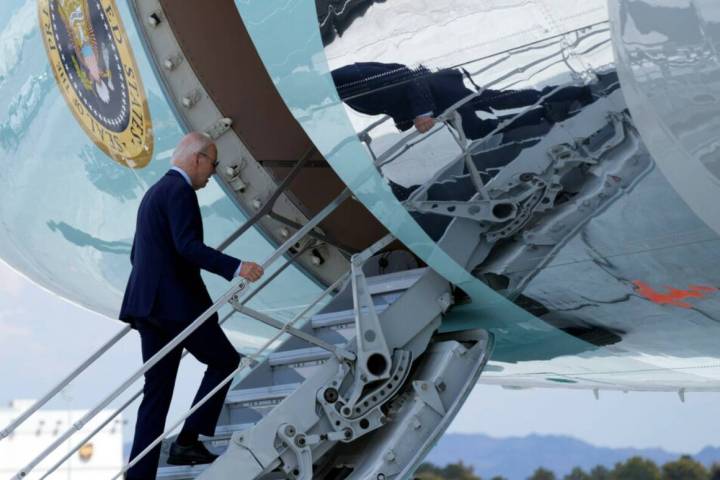 President Joe Biden walks up the steps of Air Force One at Harry Reid International Airport in ...